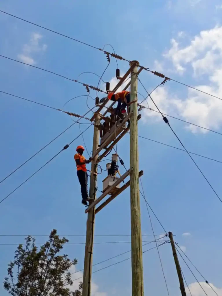 Electrical crew working on a pole-mounted transformer and power lines