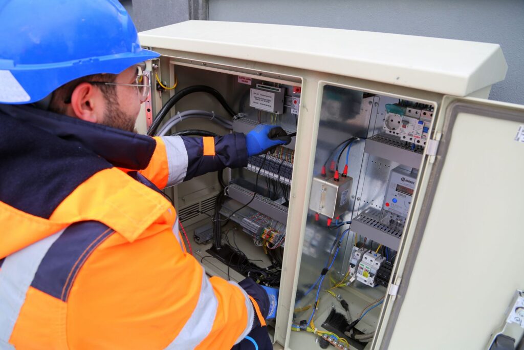 Technician inspecting an outdoor electrical control panel