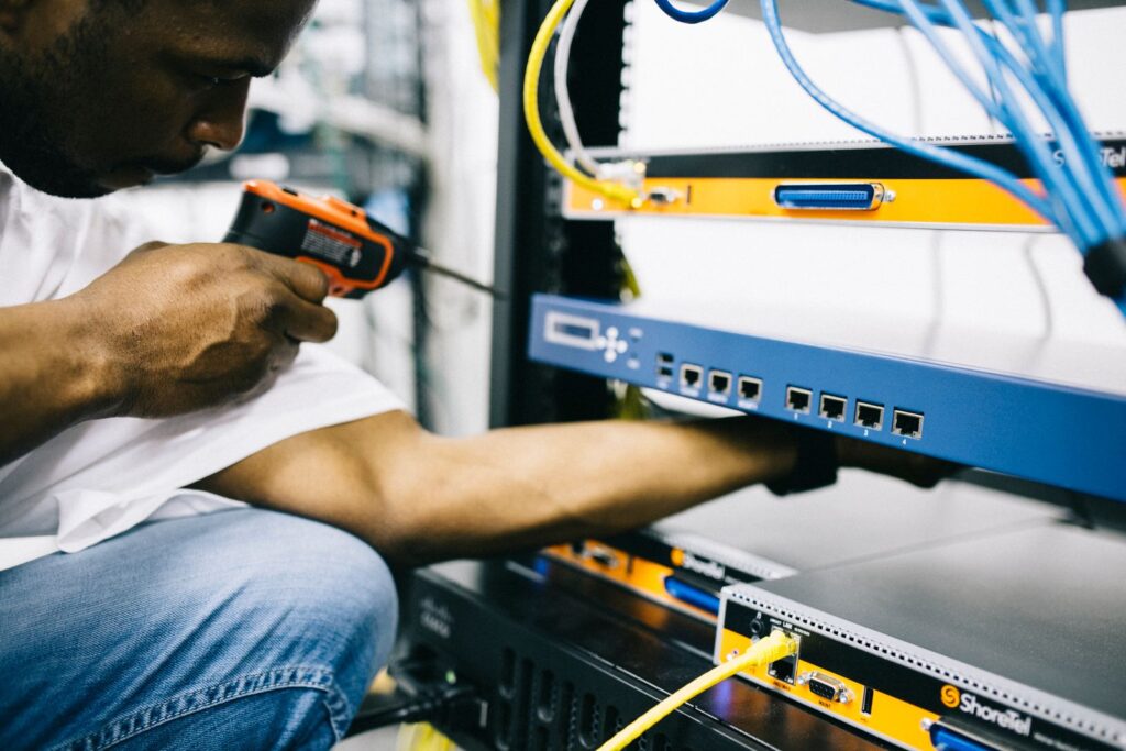 Black technician carrying out maintenance on technical equipment